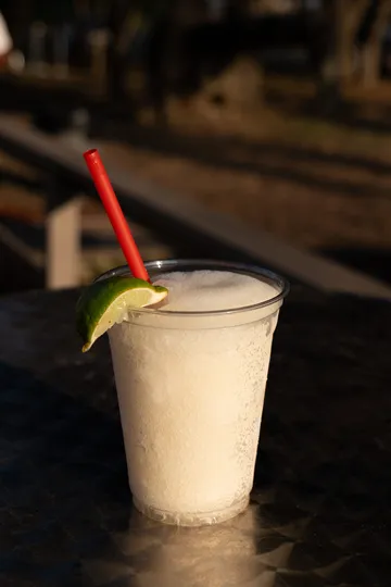 A frozen drink garnished with lime at golden hour at Paradise Live