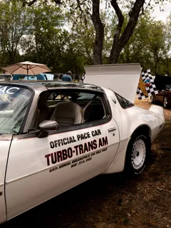 A white 1970s Trans Am marked as the official pace car on display at Paradise Live