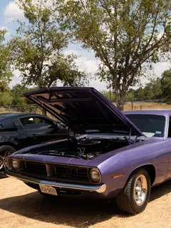 A purple Plymouth Barracuda with its hood raised at Paradise Live